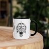 Afrocentric ceramic coffee mug with African mask art and colorful rim, handle, and interior