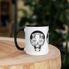 Afrocentric coffee mug featuring colorful African mask art with a vibrant rim, handle, and interior