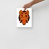 Orange and black African mask art print displayed as matte tribal wall decor