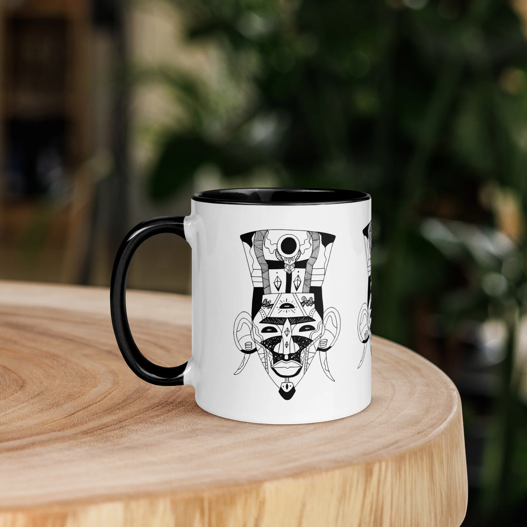 African mask art mug with black interior and handle, displaying geometric tribal design on white ceramic