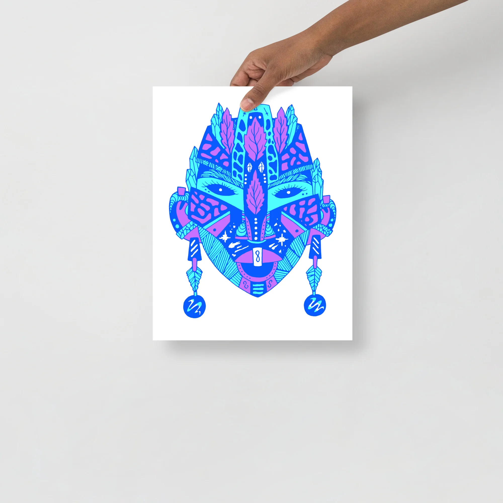 Bold abstract African mask art print in vibrant blue and magenta tones with geometric patterns and decorative leaf motifs.
