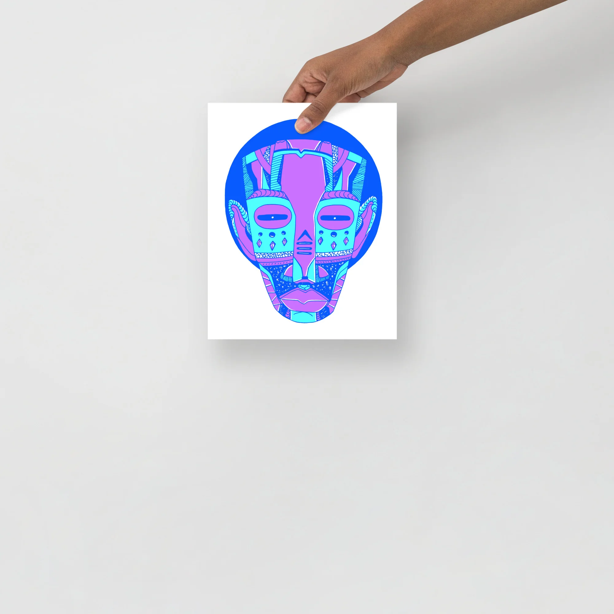 Colorful African mask art print with blue circular background, magenta and cyan tribal patterns, held up to display.