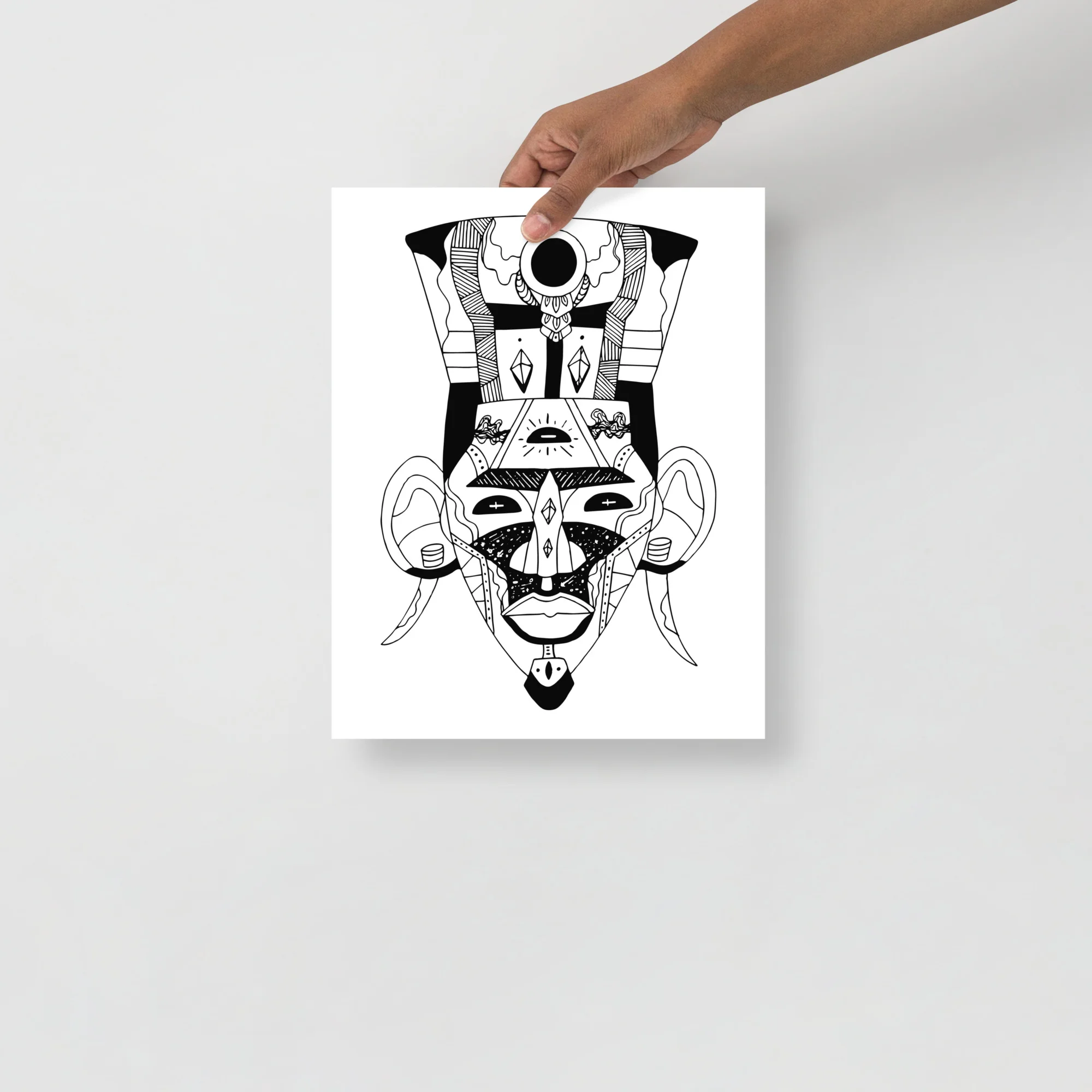 Black and white African mask art print featuring geometric tribal design with bold lines and symmetrical patterns
