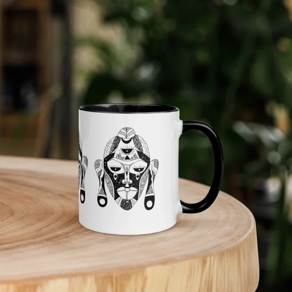 African mask coffee mug featuring intricate black geometric artwork on white ceramic with black handle