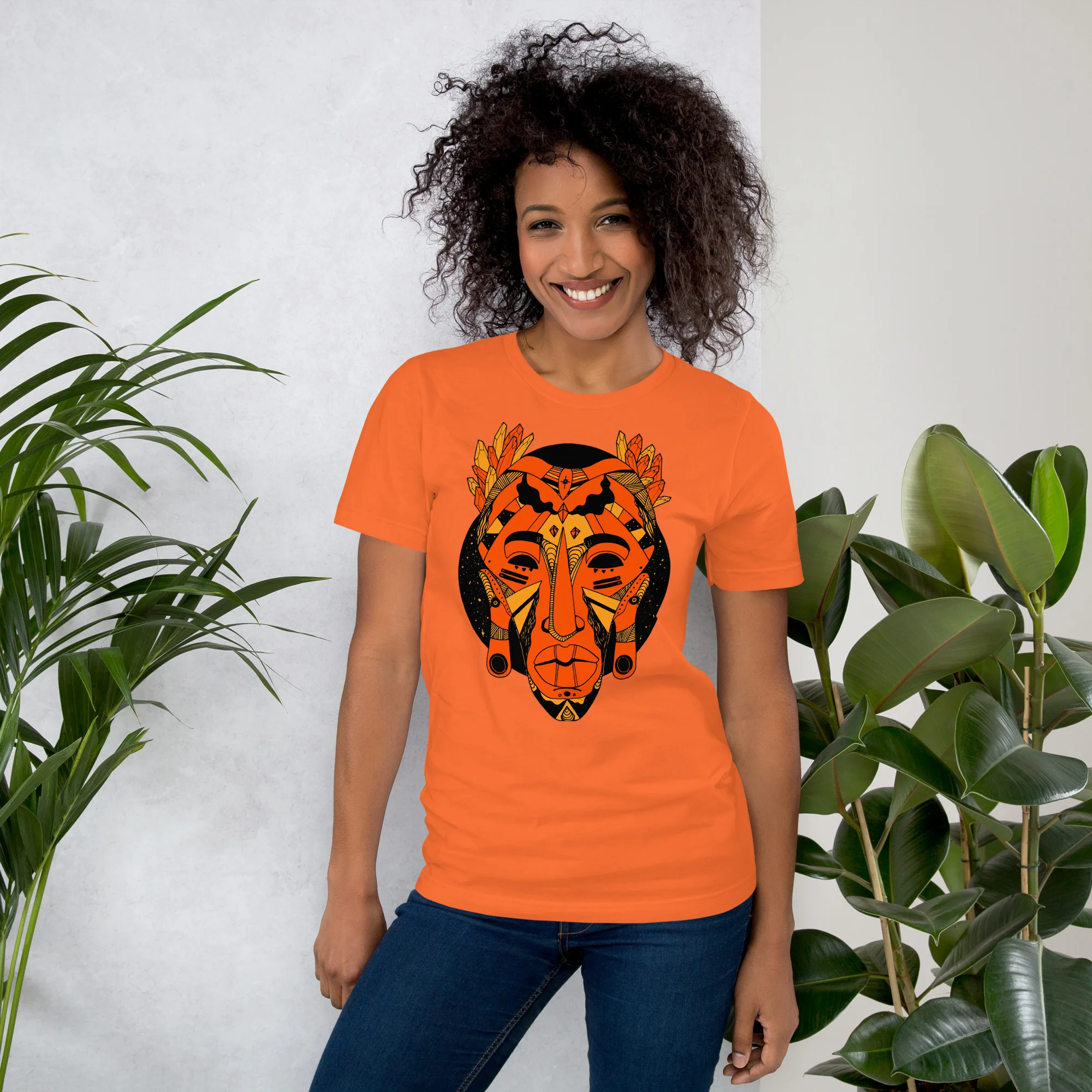 Woman wearing orange african mask t-shirt with black graphic design and butterfly details