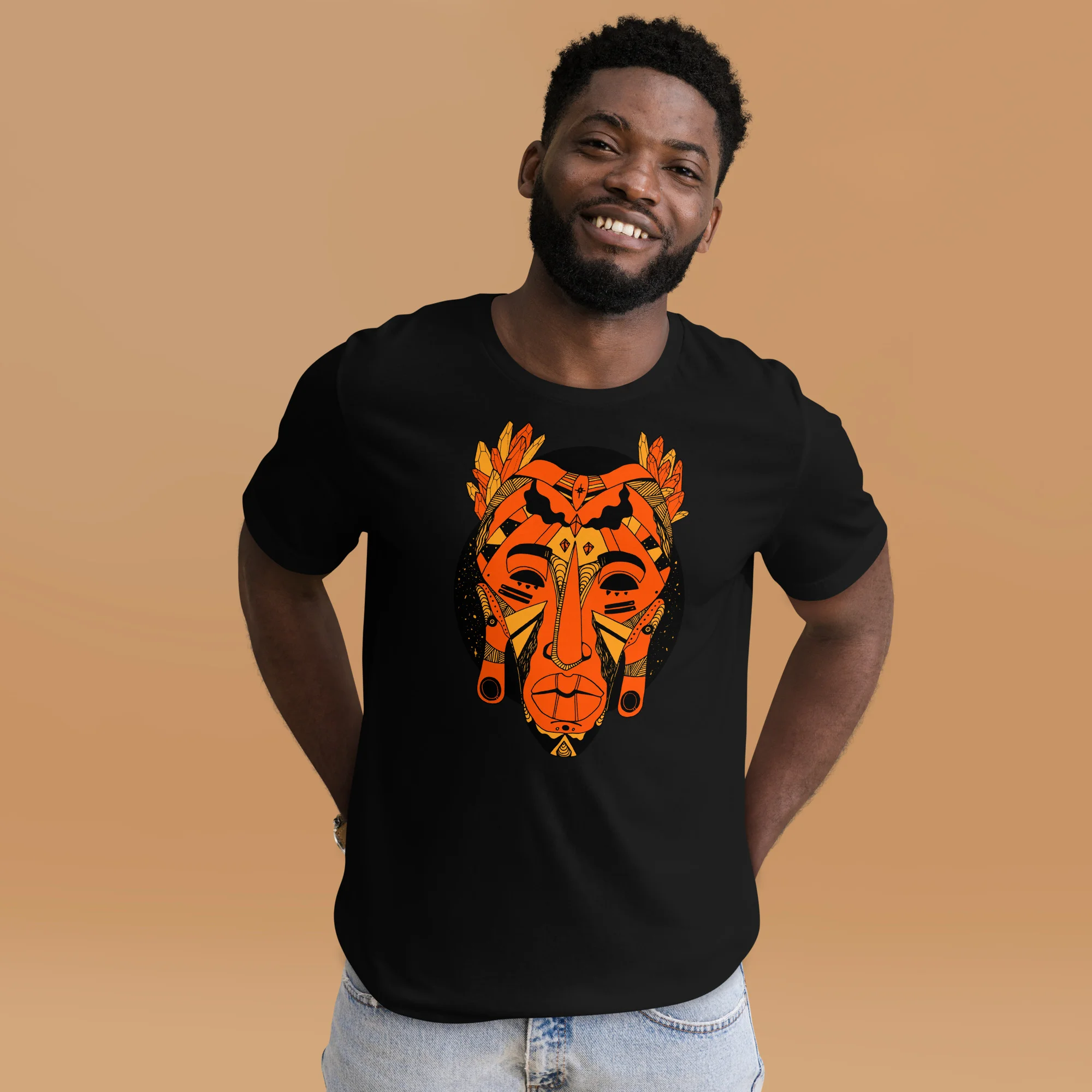 Man wearing black African mask t-shirt with orange and yellow graphic print design on tan background