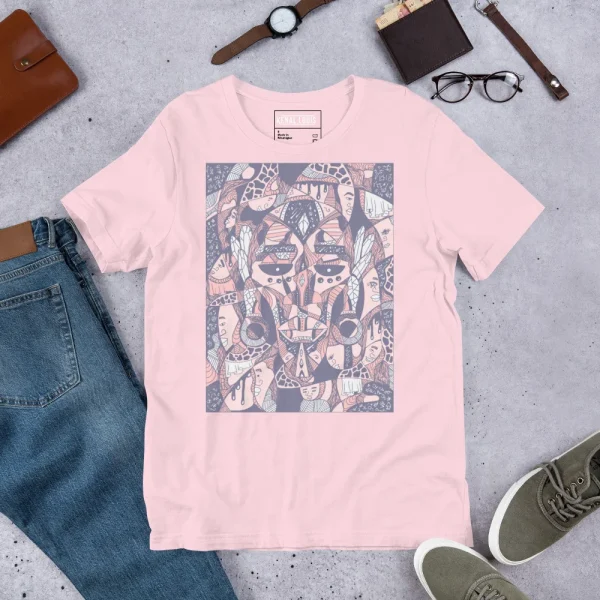 Rose pink African mask t-shirt displaying bold geometric tribal art graphic with navy and copper tones, styled flat lay with accessories