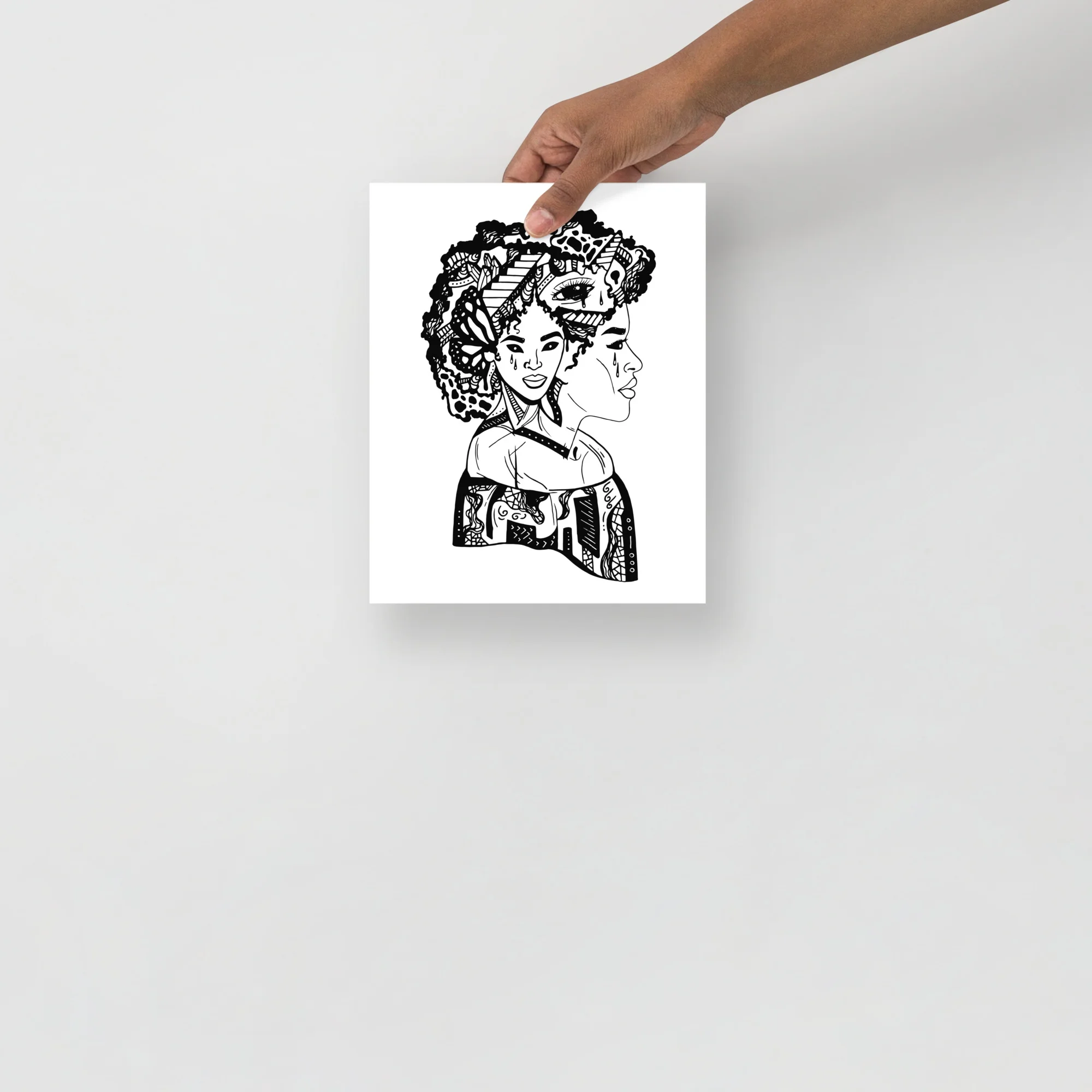 Afrocentric art print featuring a profile portrait with intricate patterned hair and decorated shoulders in black ink on white background