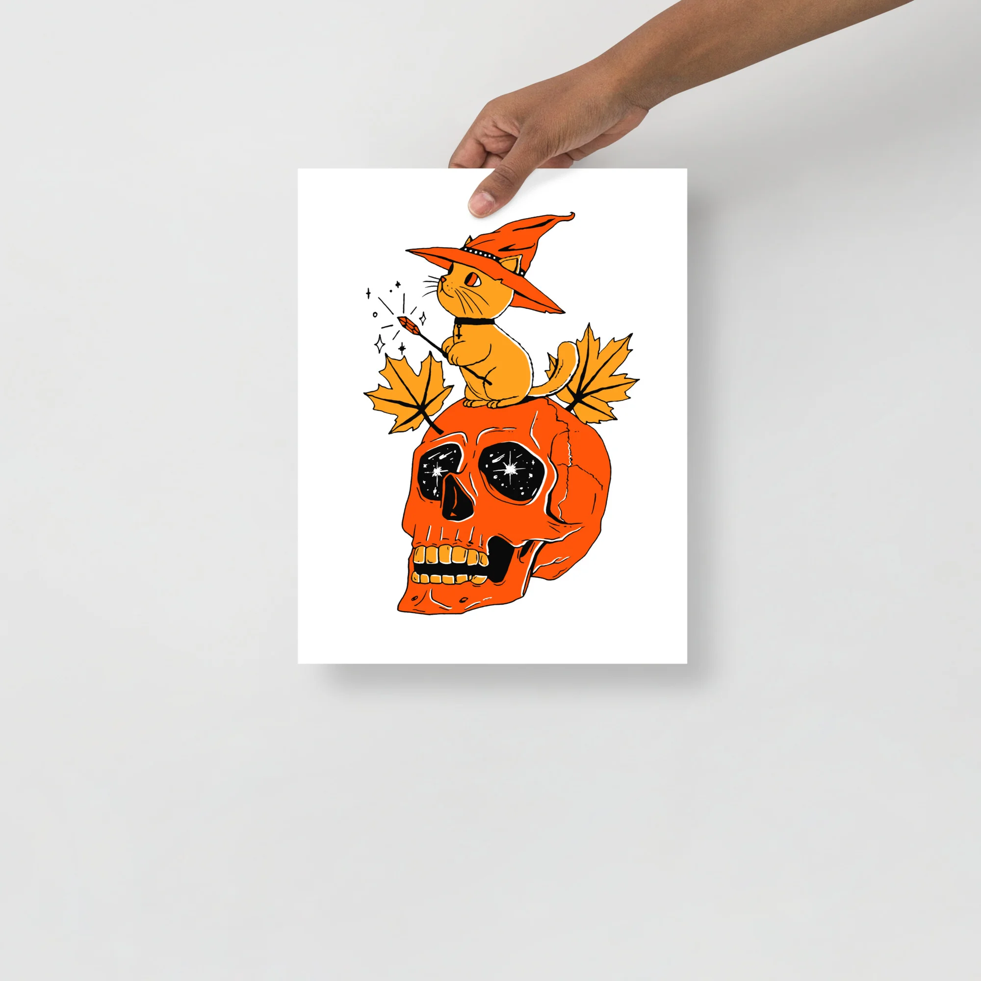 Black and orange cat art print featuring a wizard cat on an orange skull with autumn leaves and magical sparkles