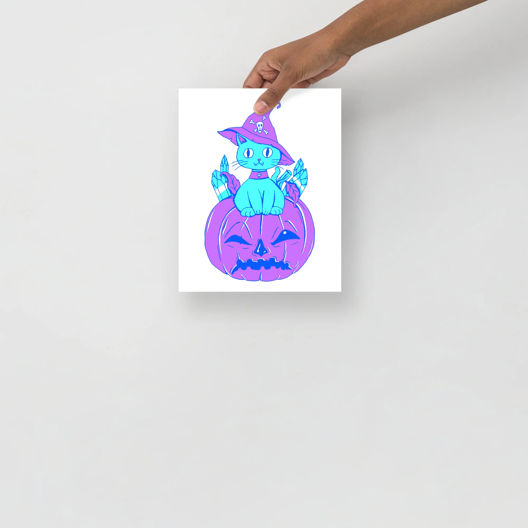 Cyan blue cat wearing a purple witch hat sits on a carved jack-o-lantern pumpkin with crystal leaves.