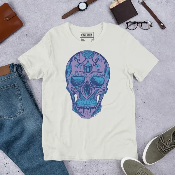 Cream Day of the Dead skull t-shirt with blue and purple calavera design displayed flat lay with accessories