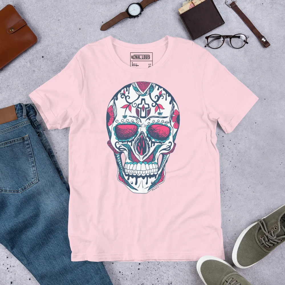 Soft pink day of the dead t-shirt featuring a colorful sugar skull with floral and cross motifs, displayed flat lay with accessories.