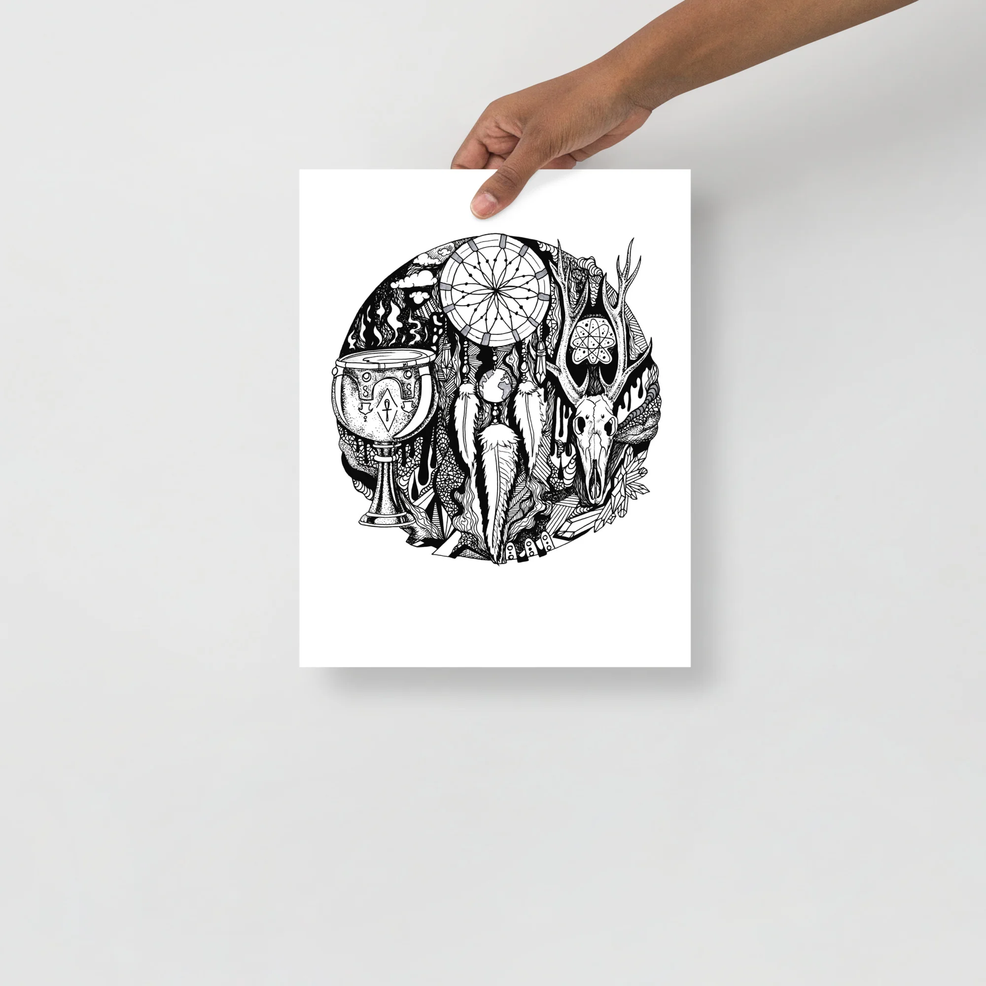 Hand holding a framed black and white dreamcatcher artwork print featuring desert motifs and symbolic imagery