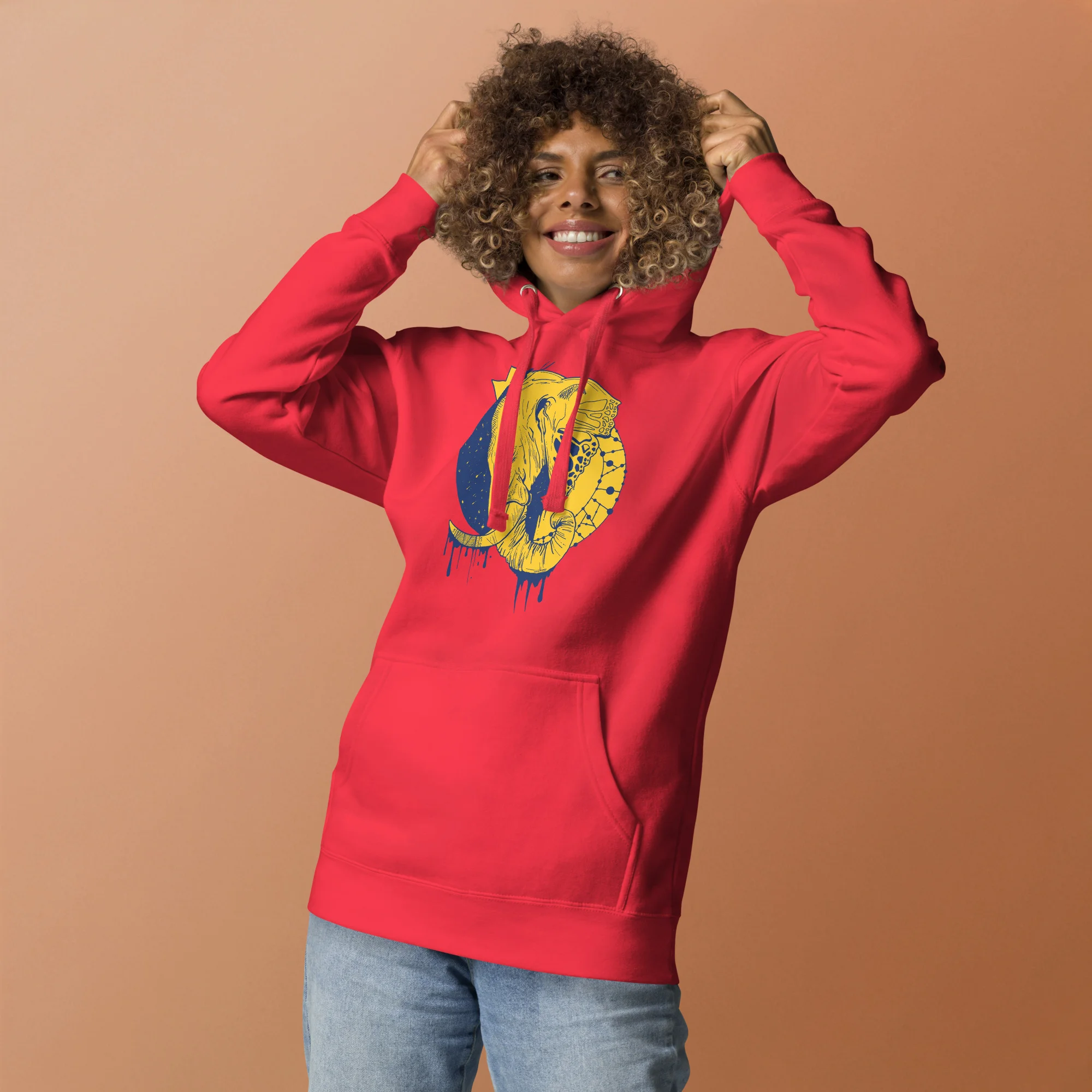 Person wearing a red elephant hoodie with yellow crowned elephant illustration on the front