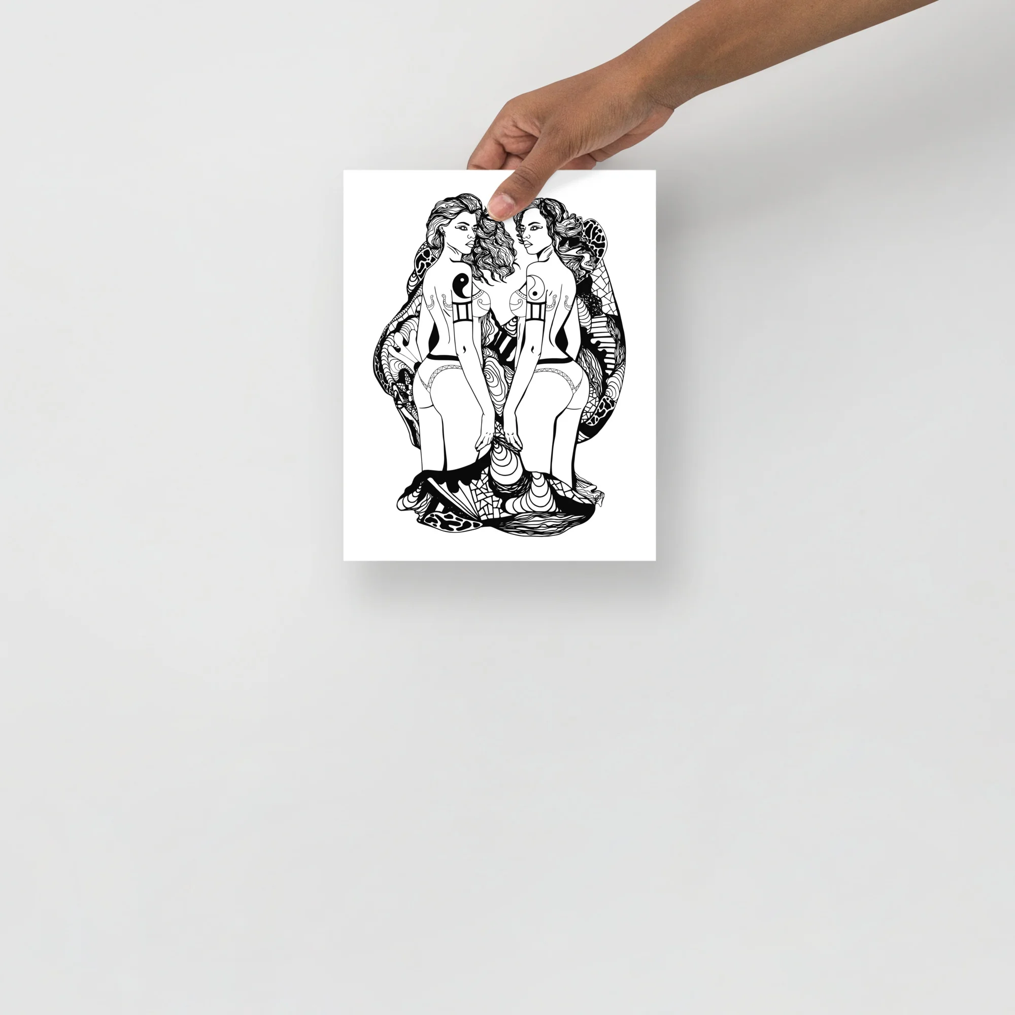 Black and white line art print depicting two feminine Gemini figures facing each other with yin-yang heart symbols