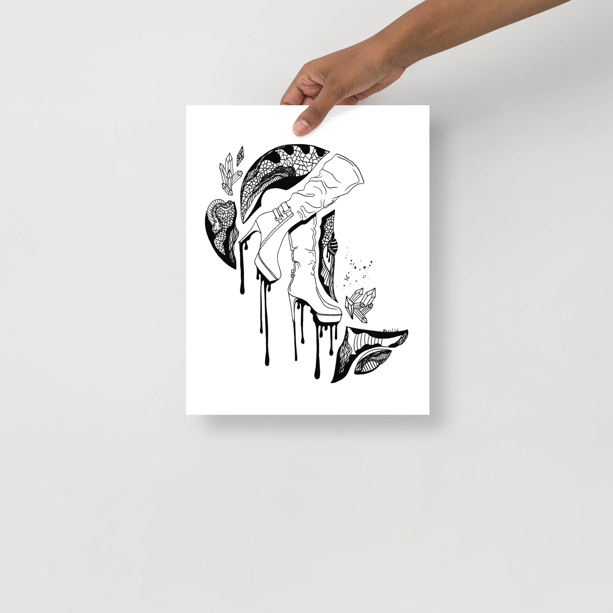 Black and white high heel art print featuring an artistic hand holding a stiletto shoe with decorative botanical elements and dripping ink details.