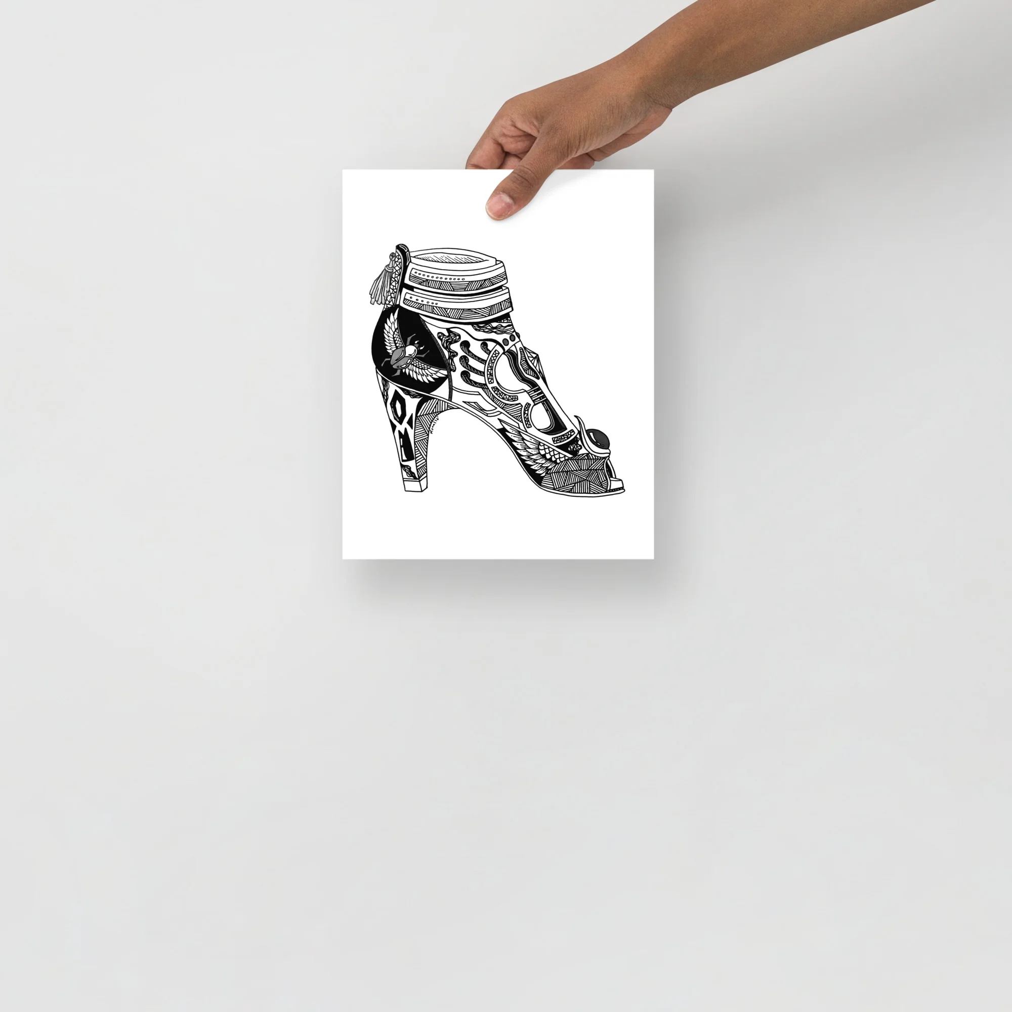 Black ink illustration of a high heel art print featuring ornate goddess heels with decorative patterning and a feathered ankle detail.