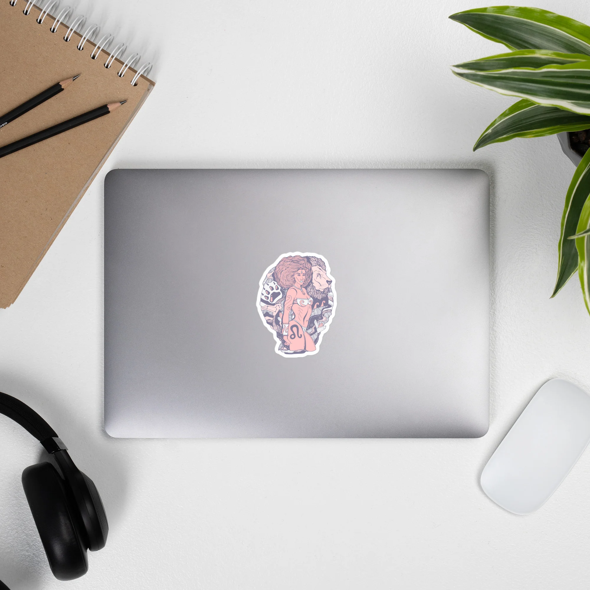 Pastel pink leo sticker featuring an Amazonian warrior design displayed on a silver laptop in a workspace setting.