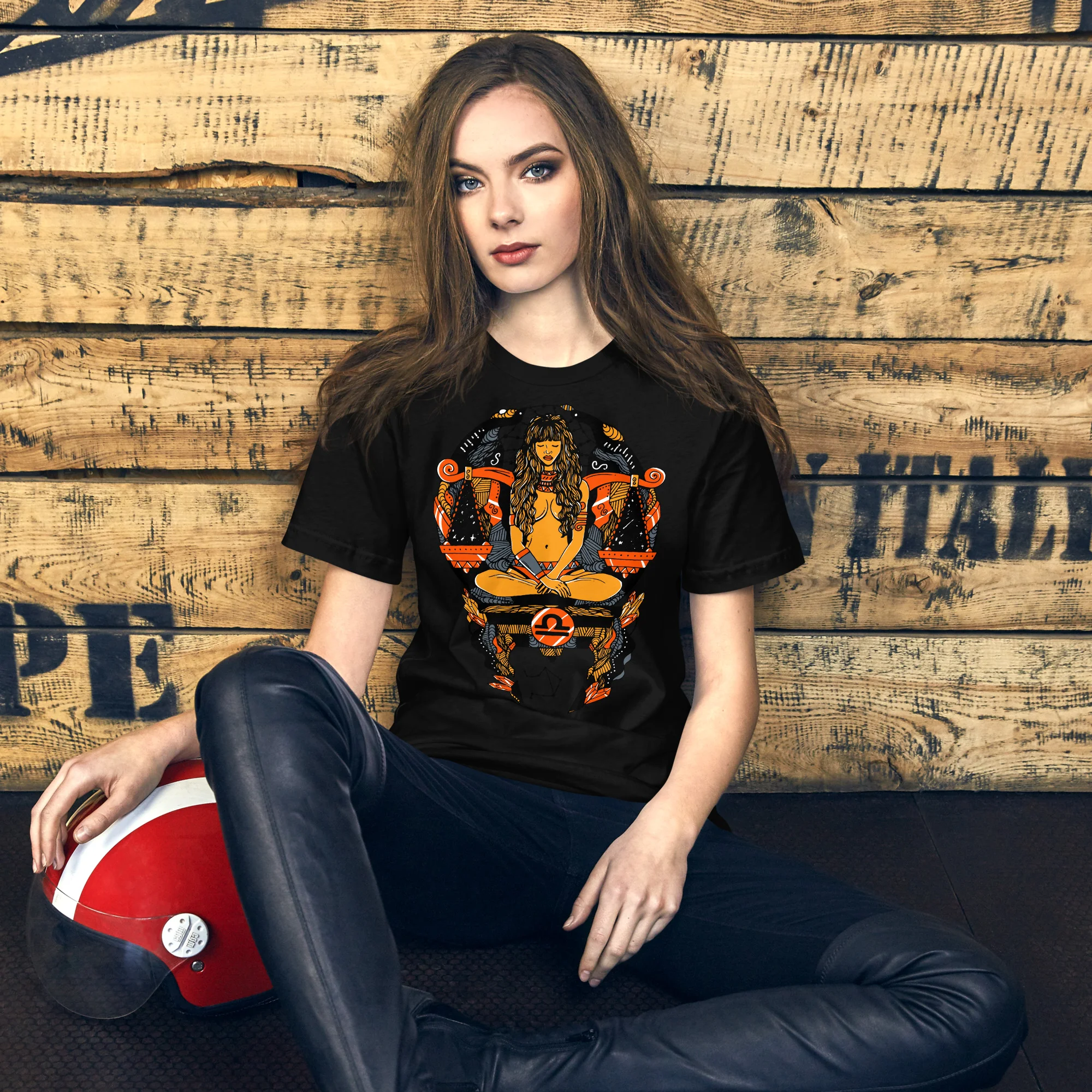 Woman wearing black libra zodiac t-shirt with orange graphic design and scales symbol