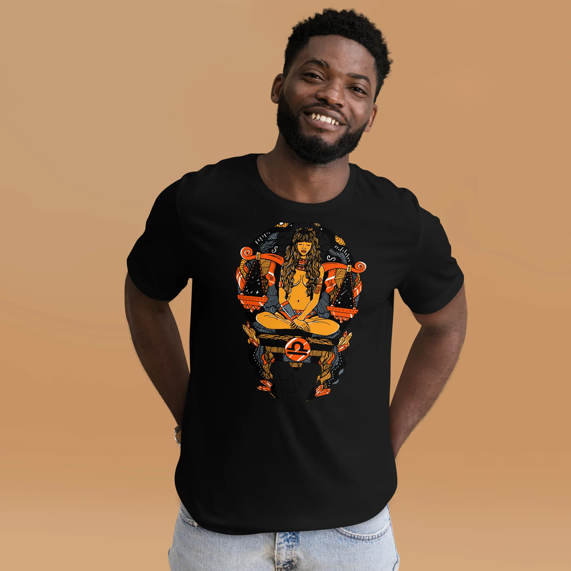 Man wearing black libra zodiac t-shirt with orange and gold graphic design against tan background