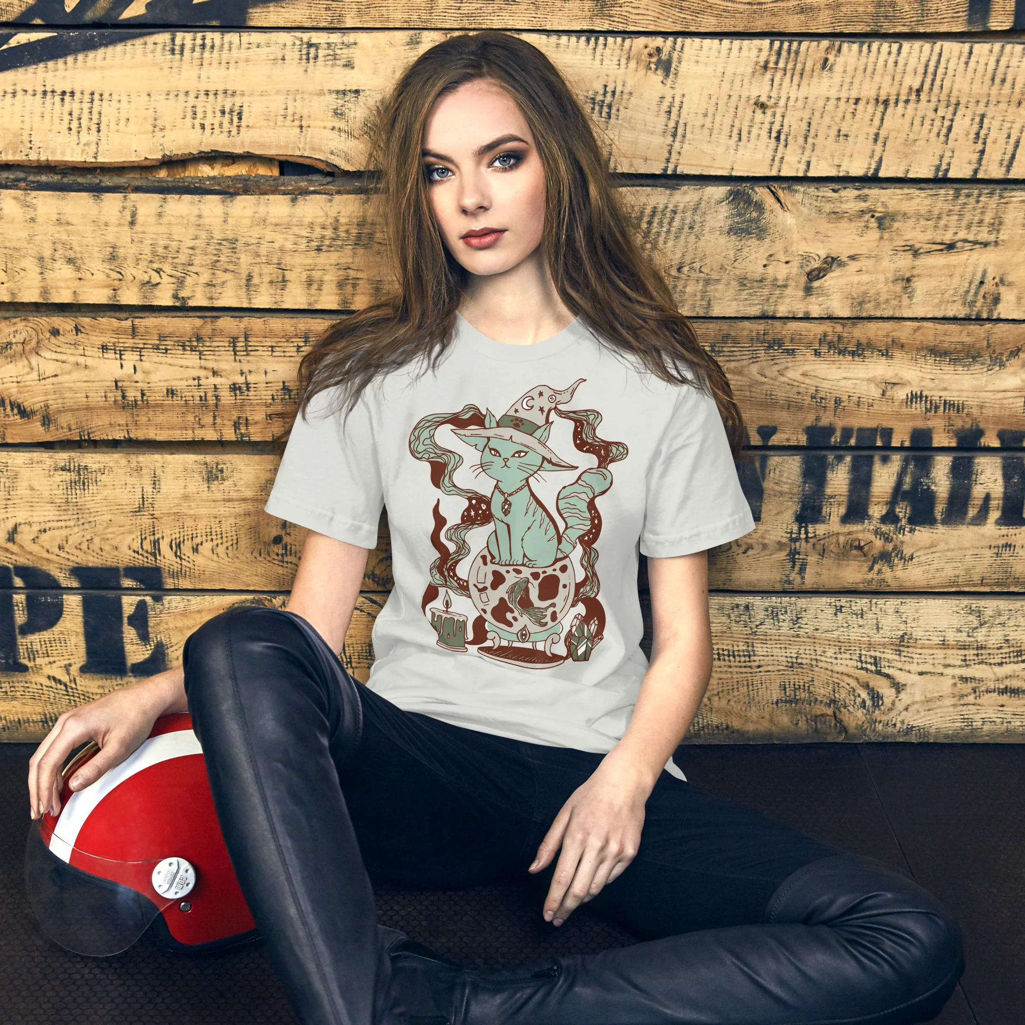 Woman wearing a sage green magical cat t-shirt with whimsical fortune design and sitting pose