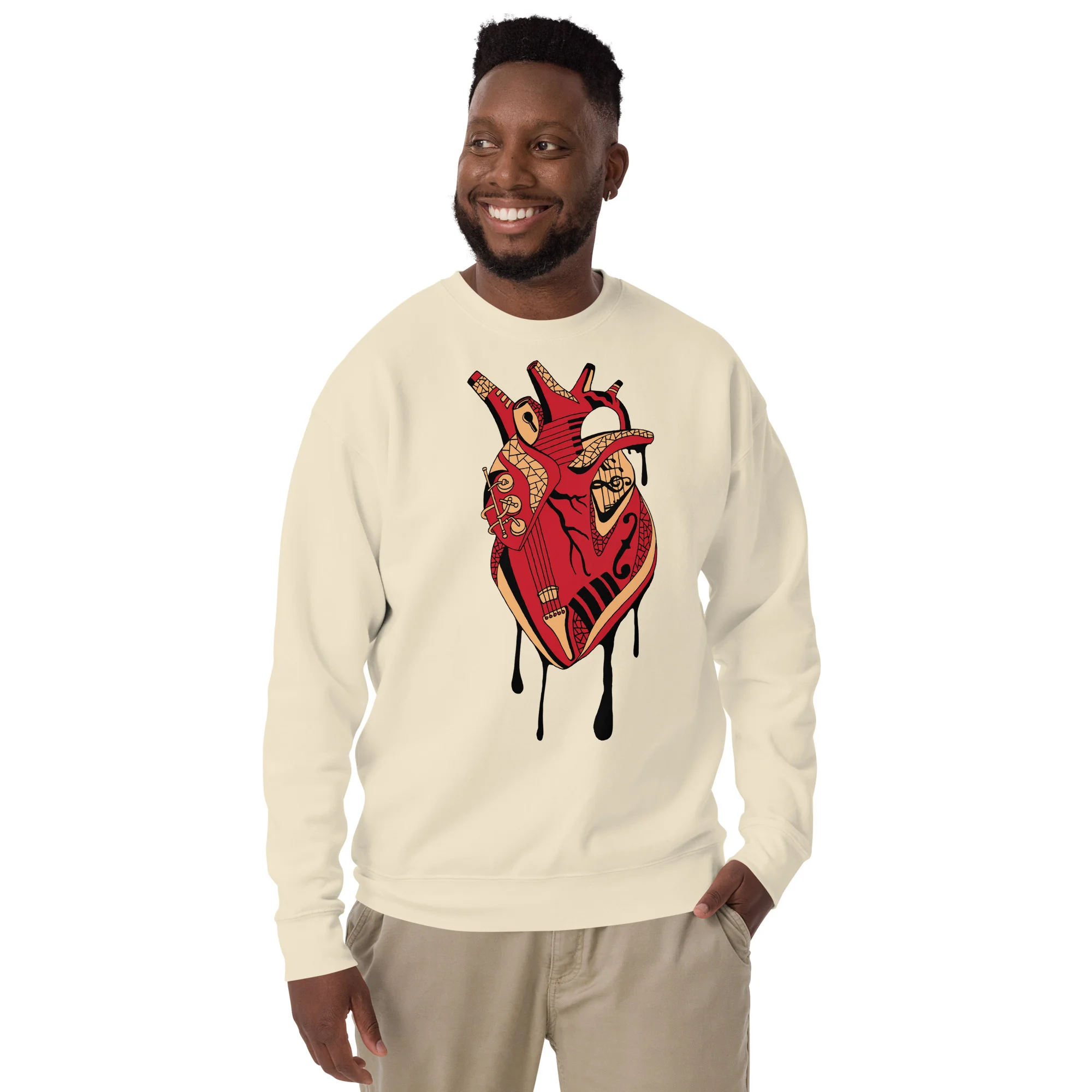 Man wearing a cream musical heart sweatshirt with red and gold decorative heart design featuring musical elements