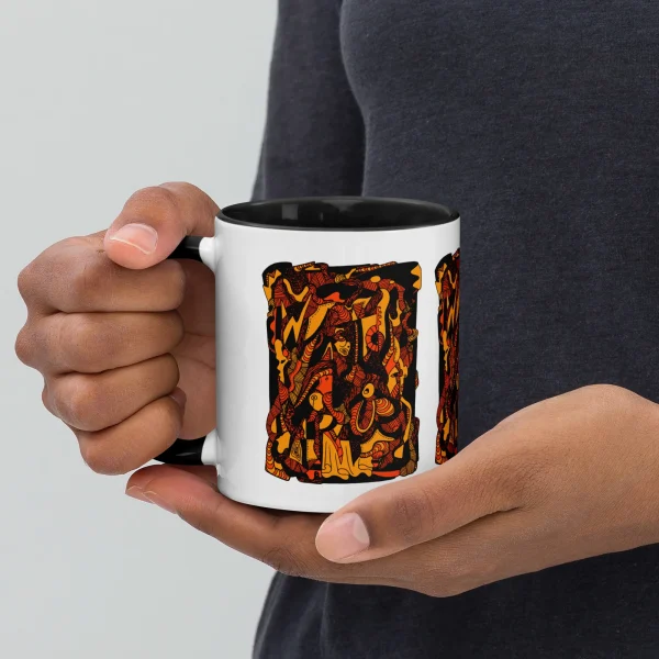 Person holding an orange and black abstract art coffee mug with intricate patterned design and black interior rim.
