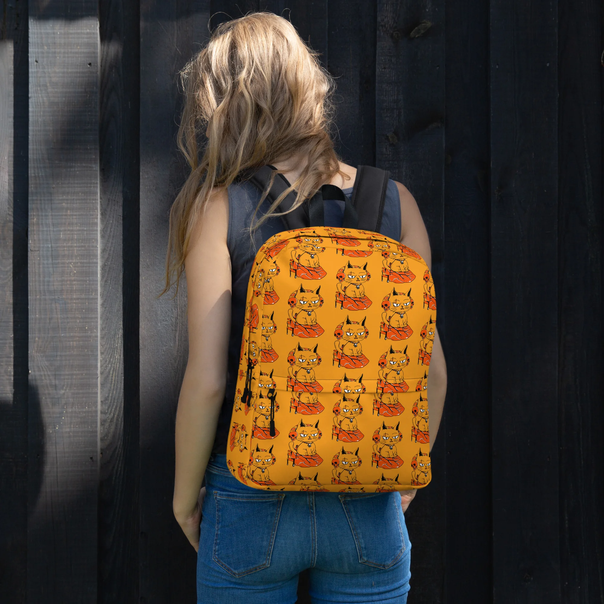 Woman wearing orange cat backpack with heart pattern design, shown from back view against dark wooden background