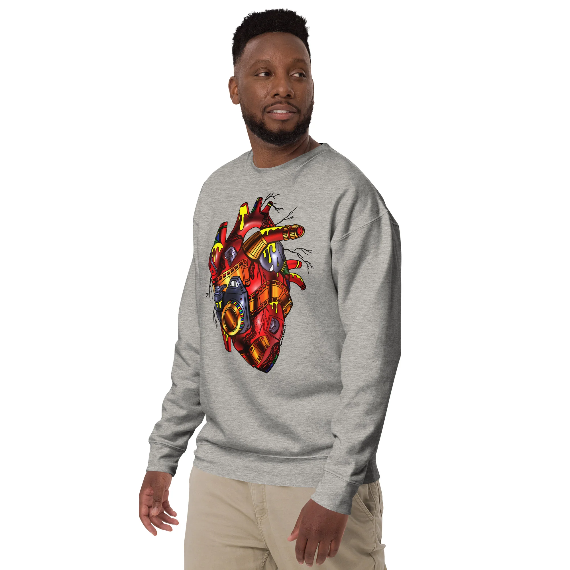 Man wearing grey photographer sweatshirt with red and cream mechanical heart artwork on chest
