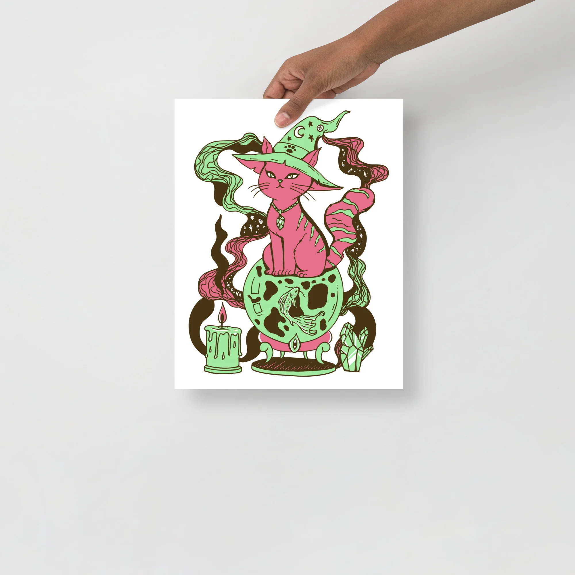 Pink cat art print wearing a witch hat surrounded by green magical swirls, fortune crystal ball, and mystical elements in whimsical illustration style.