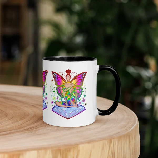 Colorful pride fairy mug with rainbow wings design and black rim, displayed on wooden table