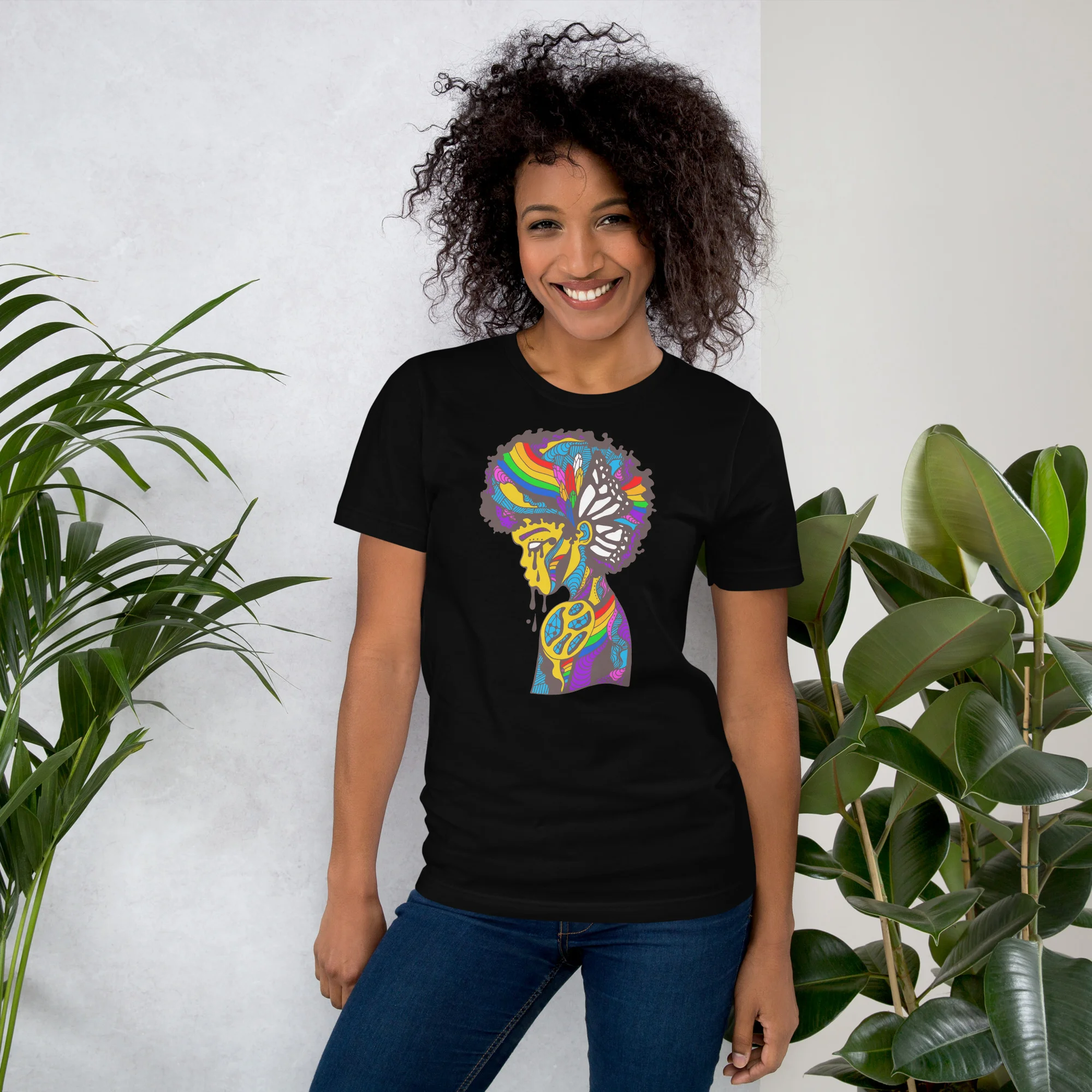 Woman wearing black pride t-shirt with colorful rainbow silhouette design featuring butterfly and abstract patterns