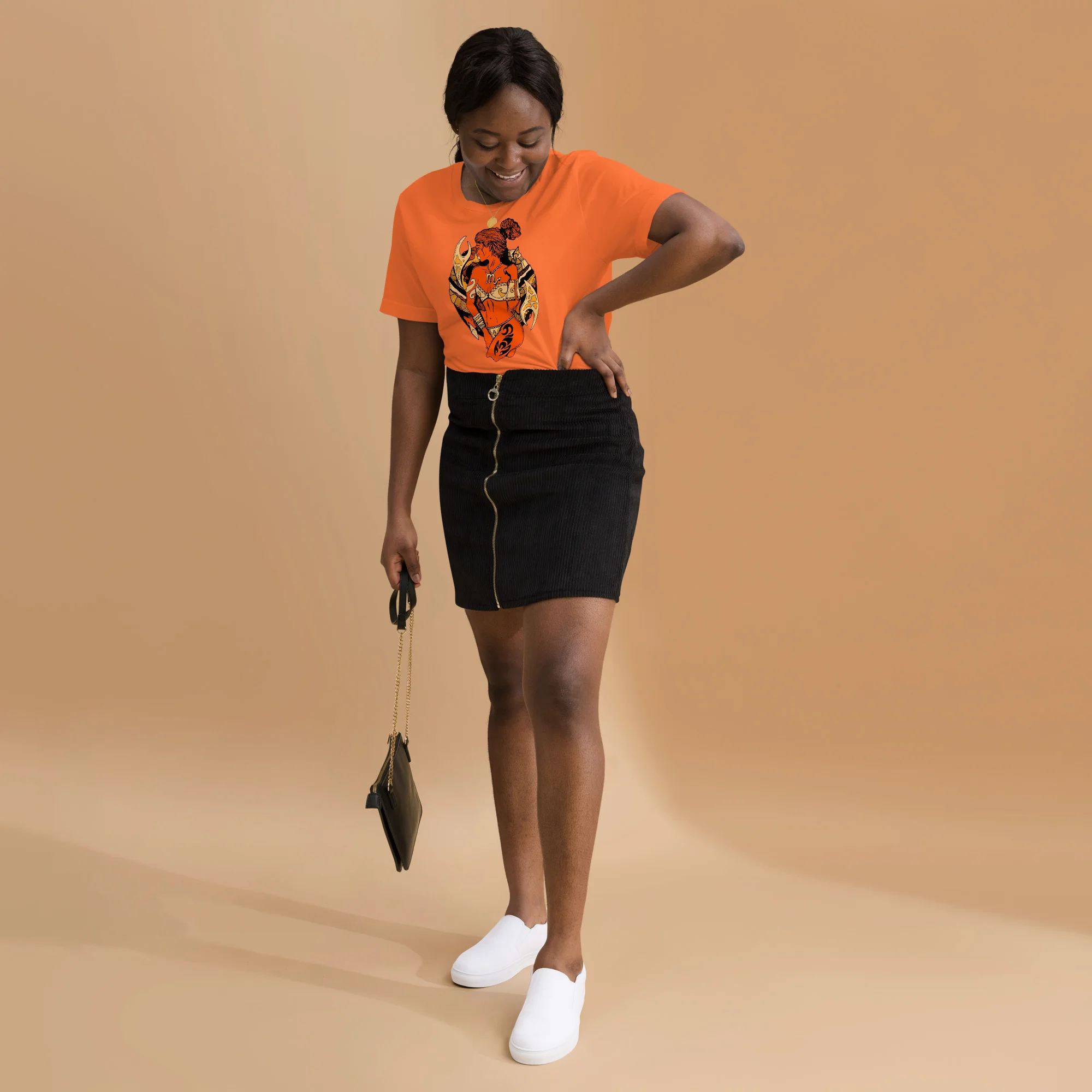 Woman wearing orange scorpio t-shirt with black warrior graphic and black mini skirt