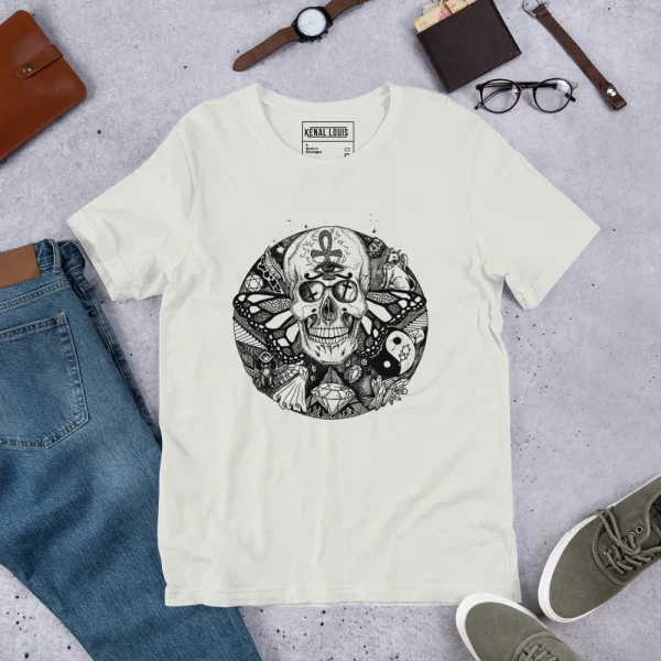 Cream skull t-shirt featuring intricate Circle of Humanity black ink design with symbolic artwork, displayed flat lay with accessories