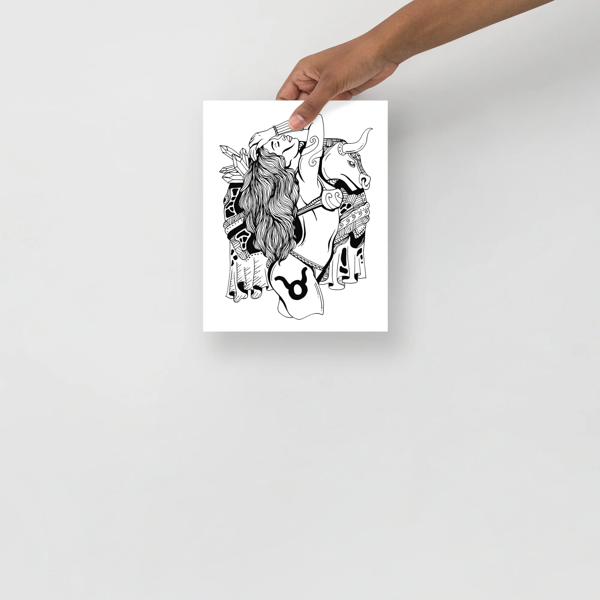 Taurus zodiac art print featuring a woman with long flowing hair beside a horned bull in elegant black line art illustration
