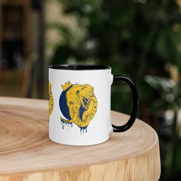 Yellow elephant mug with navy crescent moon and crown design, black handle and rim, displayed on wooden table