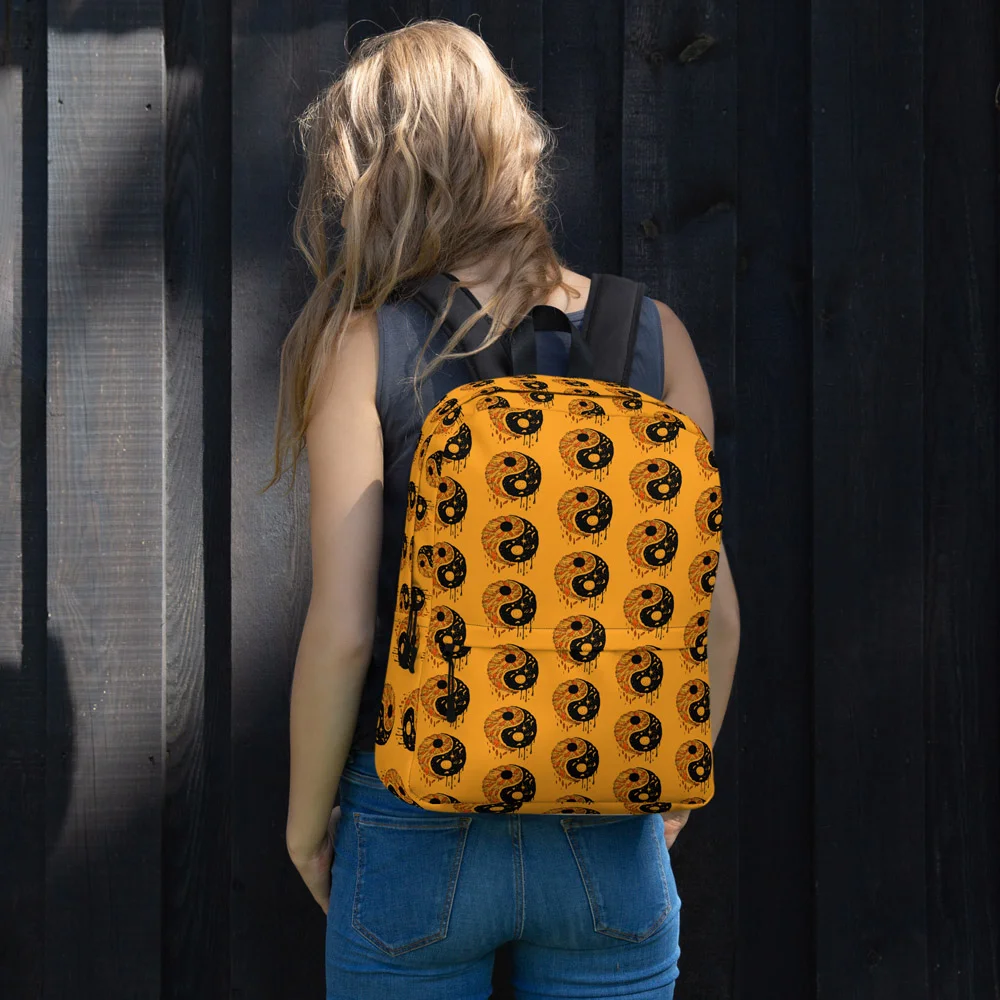 Person wearing orange and black yin yang backpack with repeating circular pattern design, rear view