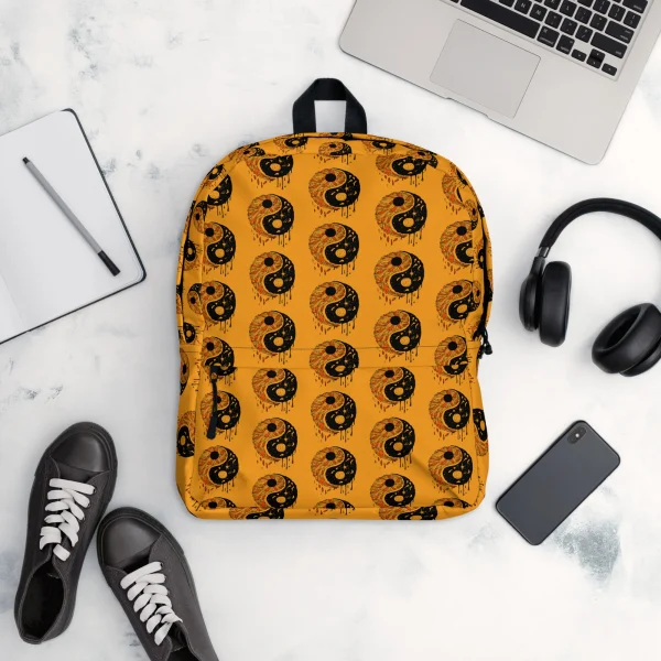 Orange and black yin yang backpack with repeating circular pattern displayed from front view with black straps.
