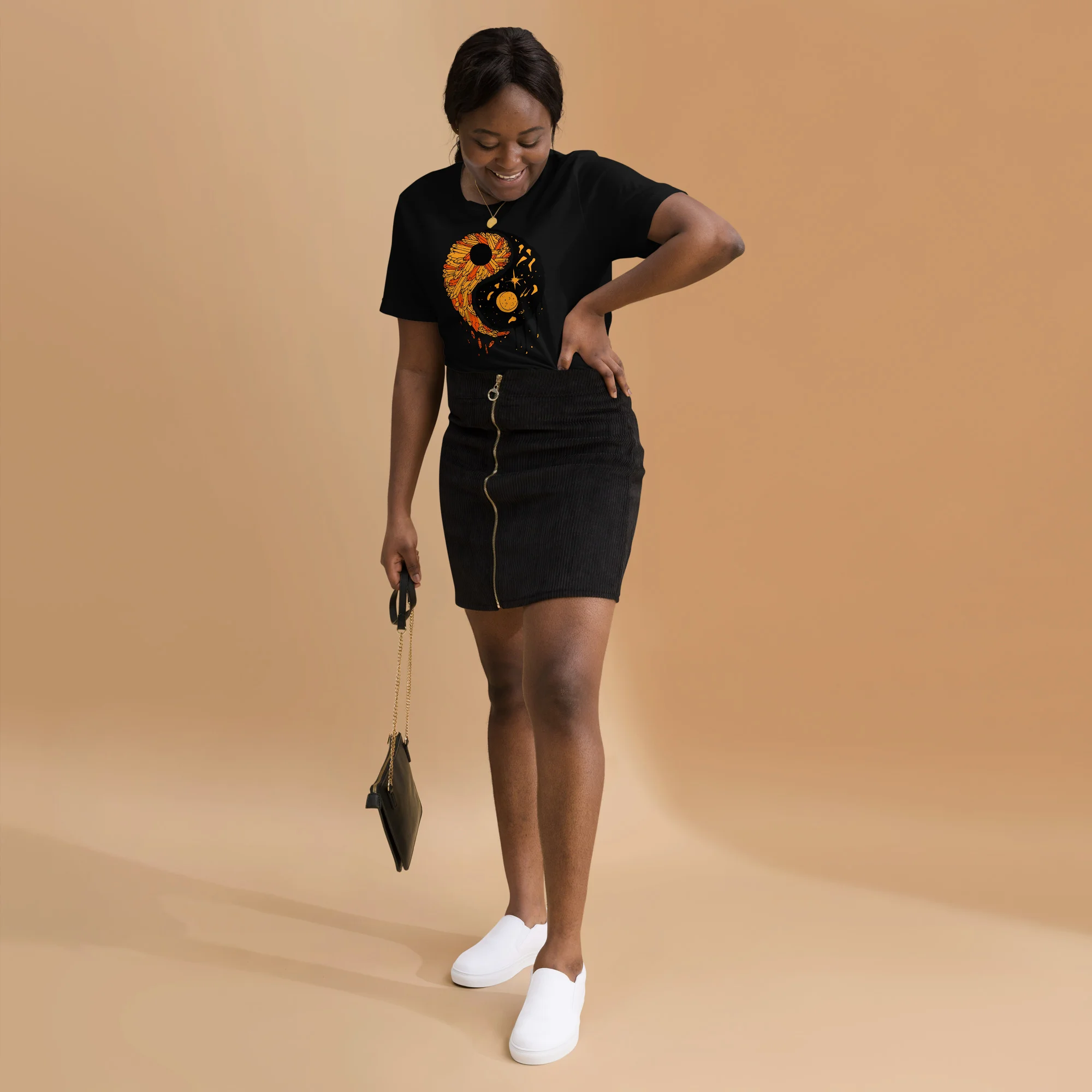Woman wearing black yin yang t-shirt with orange graphic design and black mini skirt
